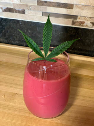 raspberry morning beauty smoothie with hemp leaf sticking out of the glass